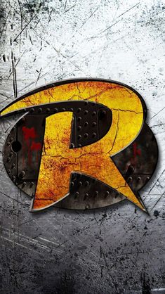 the letter r is painted yellow and black with rust on it's side, in front of a grungy background