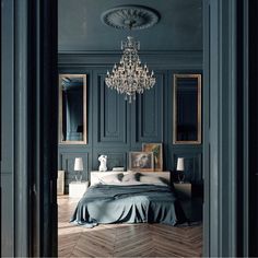 a bedroom with a chandelier hanging from the ceiling and wood flooring on the walls