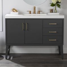 a bathroom vanity with a mirror above it and flowers on the counter top in front of it