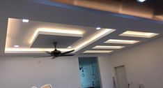 an empty room with a ceiling fan in the center and lights on the ceiling above it