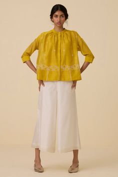 An exquisite top crafted from handwoven chanderi. Finely hand embroidered in our studio. Slim band collar and concealed placket. Delicate gathering around the neckline. 3/4 length sleeves. Two-button fastening cuff. Slip included.Note: Slight differences in embroidery speak to the hand processes involved. Garment Measurements in Inches : XS S M L XL Bust 47 49 51 53 55 Hip 56 58 60 62 64 Length 24.5 24.75 25 25.25 25.5 Top Crafts, Band Collar, Signature Print, Embroidered Top, Denim Outfit, Jacket Tops, Length Sleeve, Hand Embroidered, New Dress