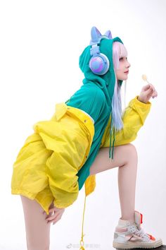 a woman in yellow and green outfit with headphones on her ears, crouching down