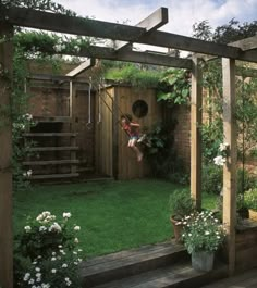 a person on a swing in the middle of a garden