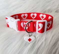 a red and white dog collar with heart shaped charms on it's front side