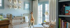 a baby's room with a crib, bookshelf and stuffed giraffe