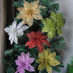 crocheted poinsettis hanging from a christmas tree