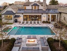 an aerial view of a house with a swimming pool and fire pit in the middle