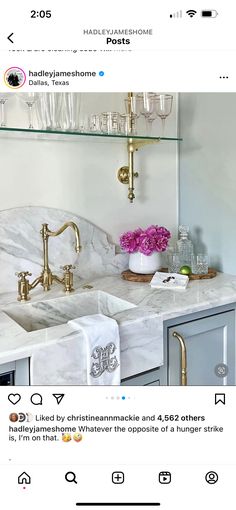 an instagramted photo of a kitchen with marble countertops and gold faucets