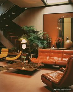 a living room filled with lots of furniture and a staircase leading up to the second floor