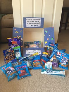 a pile of snacks sitting on the floor next to a sign