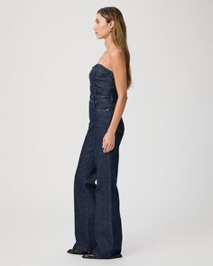 The must have one-piece of the season. Inspired by our Leenah wide leg silhouette, this strapless jumpsuit is crafted from super soft dark wash denim with a hint of stretch for comfort and features silver front buttons, elastic at the back, and light boning in the bodice. The Sansa Jumpsuit pairs perfectly with boots, heels, or flats. | Sansa Jumpsuit - Calix Blue | Size 6 Chic High Rise Strapless Jumpsuit, Fitted Wide-leg Dark Wash Jumpsuits And Rompers, Dark Wash Fitted Wide Leg Jumpsuits And Rompers, Fitted Dark Wash Wide Leg Jumpsuits And Rompers, Fitted Wide Leg Dark Wash Jumpsuit, Dark Wash Fitted Wide Leg Jumpsuit, Wide Leg Denim Strapless Jumpsuit, Chic Dark Wash Wide Leg Denim Jumpsuit, Strapless Wide Leg Denim Jumpsuit