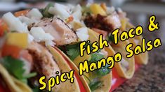 three fish tacos and spicy mango salsa on a red tray with the words fish taco and spicy mango salsa