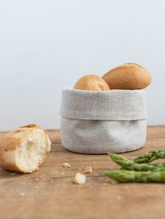 bread and asparagus on a wooden table with a white cloth wrapped around it