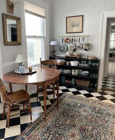 a dining room table and chairs in front of a checkerboard floor with an area rug