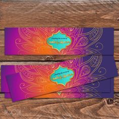 two purple and orange business cards sitting on top of a wooden table