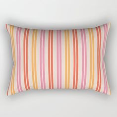 an orange and pink striped pillow on a white wall