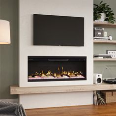 a living room with a fireplace and television mounted on it's wall above a wooden floor