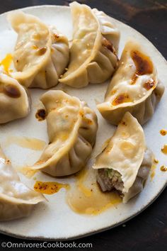 some dumplings are sitting on a white plate