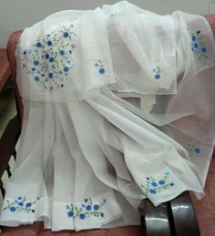 white sheer curtains with blue flowers on them