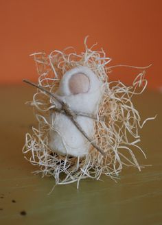 a small white stuffed animal sitting on top of a wooden table