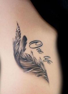 a woman's back with a feather and the words one love written on it