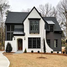 a white and black house with lots of windows on the front door is shown in this image