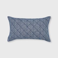 a blue and white pillow on a gray background