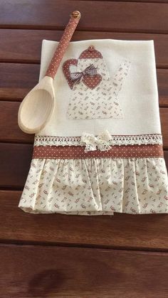 a wooden spoon sitting on top of a table next to a white cloth with a teddy bear