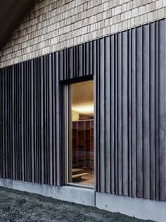 an open window on the side of a brick building with metal slats covering it