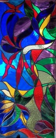 a close up of a stained glass window with many different colors and shapes on it