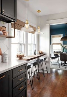 a kitchen with wooden floors and black cabinets