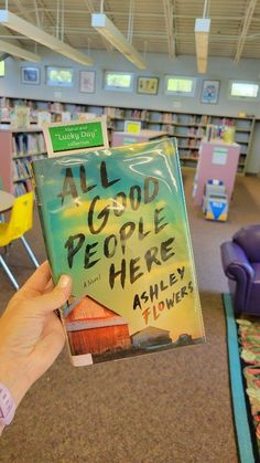 a person holding up a book in a library