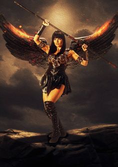 a woman dressed as an angel holding two swords in her hands and standing on top of a rock