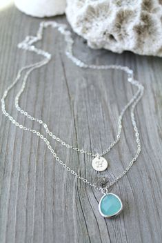 "A set of two sterling silver necklaces, made with one custom stamped initial disc and one gorgeous framed gemstone, attached on shimmering sterling silver chains. Please select initial and glass pendant from the drop down menus and indicate the length combo you need in the personalization window. The model is wearing a 17\"/19\" combo. You will receive TWO SEPARATE NECKLACES, each with its own clasp. You have the option to wear each necklace separately or put them on together for a gorgeous lay Personalized Round Turquoise Jewelry, Personalized Turquoise Sterling Silver Necklaces, Personalized Sterling Silver Turquoise Necklaces, Blue Stamped Necklace As Gift, Blue Stamped Jewelry For Gifts, Blue Stamped Jewelry For Gift, Layered Initial Necklace, Embossed Jewelry, Monogram Bracelet