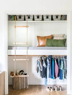 an open closet with clothes and shoes on the shelves