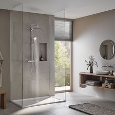 a bathroom with a walk in shower next to a sink and mirror on the wall