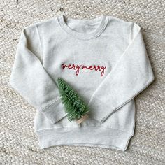 Make this Christmas extra merry for your little ones with our Youth Very Merry Embroidered Crewneck Sweatshirt! This festive and cozy sweatshirt is the perfect holiday apparel for kids, combining comfort and style for the most wonderful time of the year! Sample shown with Red thread on Heather Oatmeal sweatshirt. Design will be embroidered as Very Merry with your choice of thread.  Features: -60/40 cotton/polyester - Coverstitched collar, shoulders, armholes ribbed cuffs and waistband Please pro Embroidered Christmas Sweatshirt, Embroidered Sweaters, Stitch Sweatshirt, Team Sweatshirts, Christmas Apparel, Toddler Top, Baby Print, Holiday Apparel