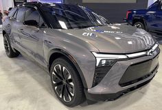 an electric suv is on display in a showroom with two other cars behind it