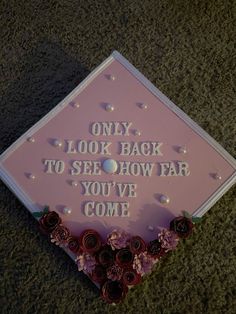 a pink graduation cap that says, only look back to see how far you've come