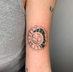 a woman's arm with a clock tattoo on the left side of her arm