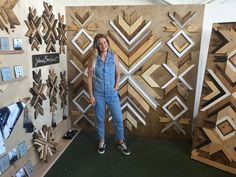 a woman standing in front of some wooden art pieces