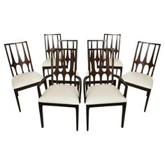 six chairs with white upholstered back and arms, all in different shapes and sizes