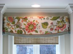 a window with a flowered valance hanging over it's windowsills