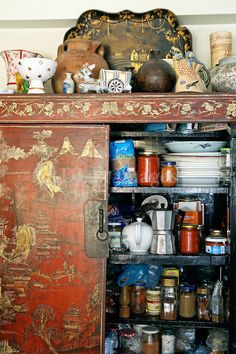 an old wooden cabinet filled with lots of different types of spices and condiments