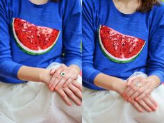 two women wearing blue shirts with watermelon slices on them, sitting next to each other