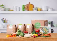 several bags of food sitting on top of a table next to some vegetables and fruits