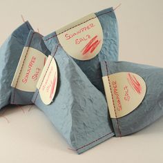 two pieces of blue paper with red writing on them and some tags attached to it