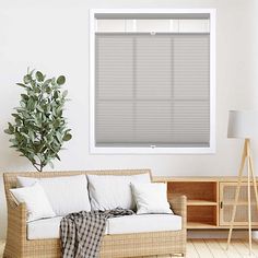 a living room with a couch, table and window blinds in shades on the windowsill