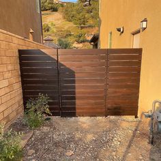 a wooden fence in front of a building with a fire hydrant next to it