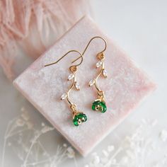 "Emerald Green Flower Earrings // Gold Filled Earrings // Boho Bridal Earrings // Floral Earrings // May Birthstone // Leaf Earrings // Birthday Gift // Bridesmaids Earrings // Four Leaf Clovers  :: Provide an enchanting effect with these lush emerald green floral earring for your woodland wedding :: These emerald green flower earrings are a delicate and feminine design perfect for any boho wedding attire or for adding a little sparkle to your next special occasion. The tiny verdant flower petals are created with faceted glass and are reminiscent to four leaf clovers. These dainty flowers are secured to golden stems featuring small cubic zirconia leaves. The lush green flower earrings are light weight and suspended from comfortable 14k gold filled earrings.  Whether adding these flower ear Anniversary Drop Earrings With Birth Flower Detail, Anniversary Birth Flower Drop Earrings, Birth Flower Drop Earrings For Wedding, Flower Shaped May Birthstone Jewelry, Mother's Day Green Flower Jewelry, Flower Shaped Crystal Earrings With Flower Charm For Gifts, Flower-shaped Crystal Earrings With Flower Charm As Gift, Flower Shaped Crystal Earrings With Flower Charm, Flower-shaped Crystal Earrings With Flower Charm